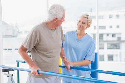 therapist guiding senior man in walking