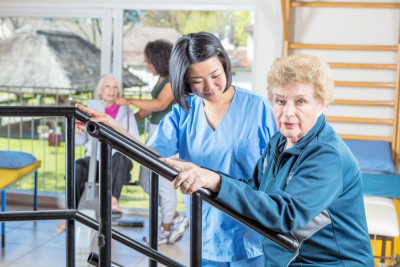 therapist assisting senior woman in balancing